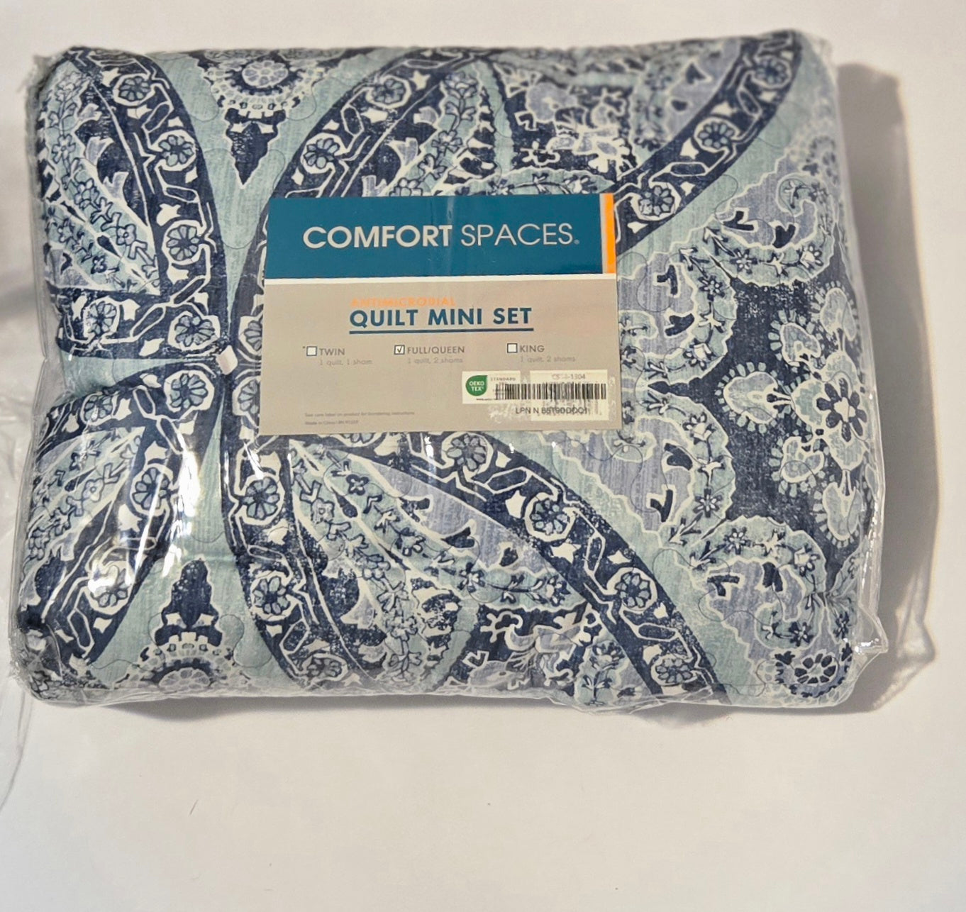 Packaged quilt mini set with 'Comfort Spaces' label with a modern pattern design on a white background